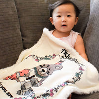 Baby girl snuggling her Adventure Security Blanket on the sofa