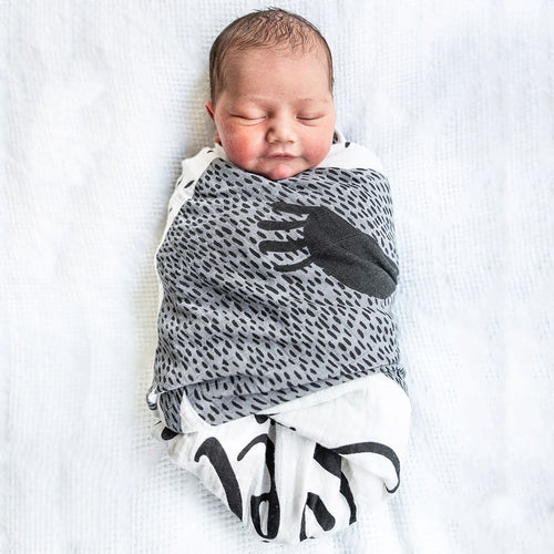 New born wrapped like a burrito with Lil Be organic muslin swaddle
