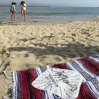 Two girls at the beach with their "Togetherness is our Favorite Place to Be" Patch Mexican Blanket