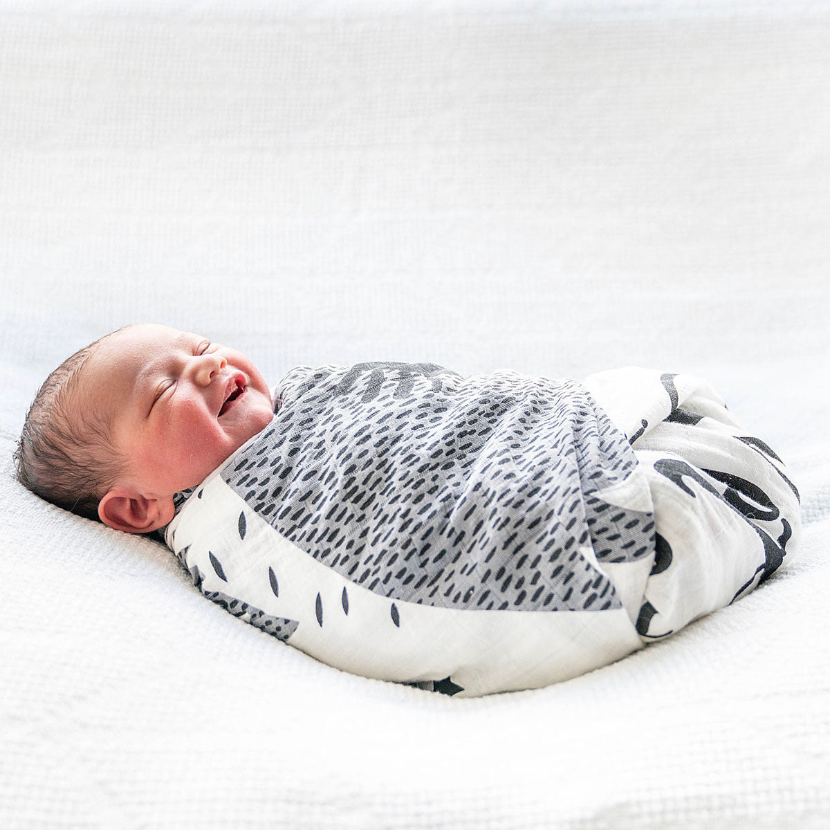 Newborn baby wrapped like a burrito with Lil Be Swaddle blanket
