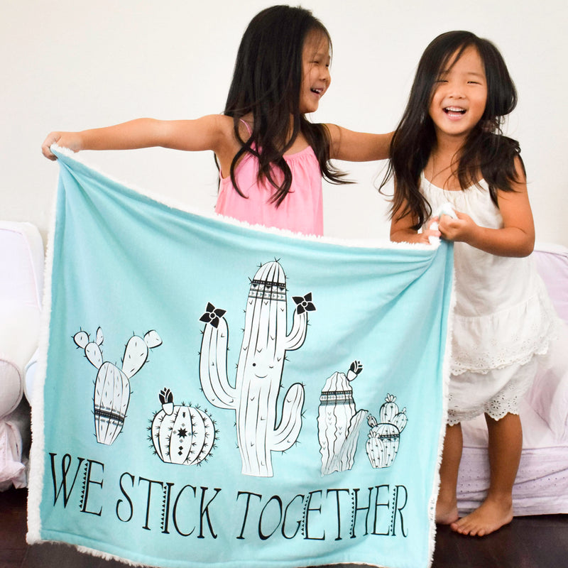 Two sister having fun with their We Stick Together Cozy Blanket
