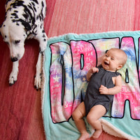 Baby Girl and Dog Laying on Dream Big Baby Blanket