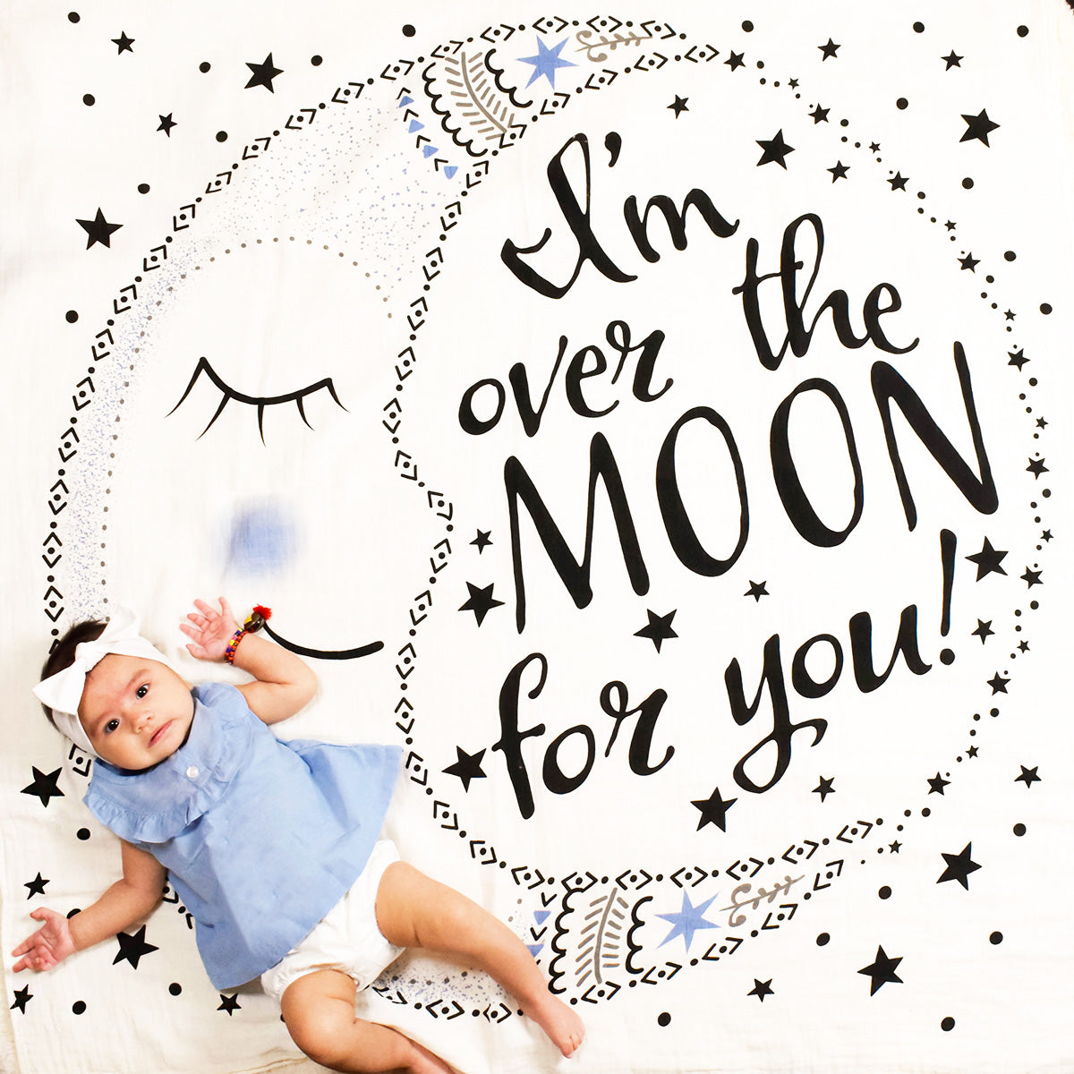 Baby girl on I'm over the Moon for you swaddle blanket